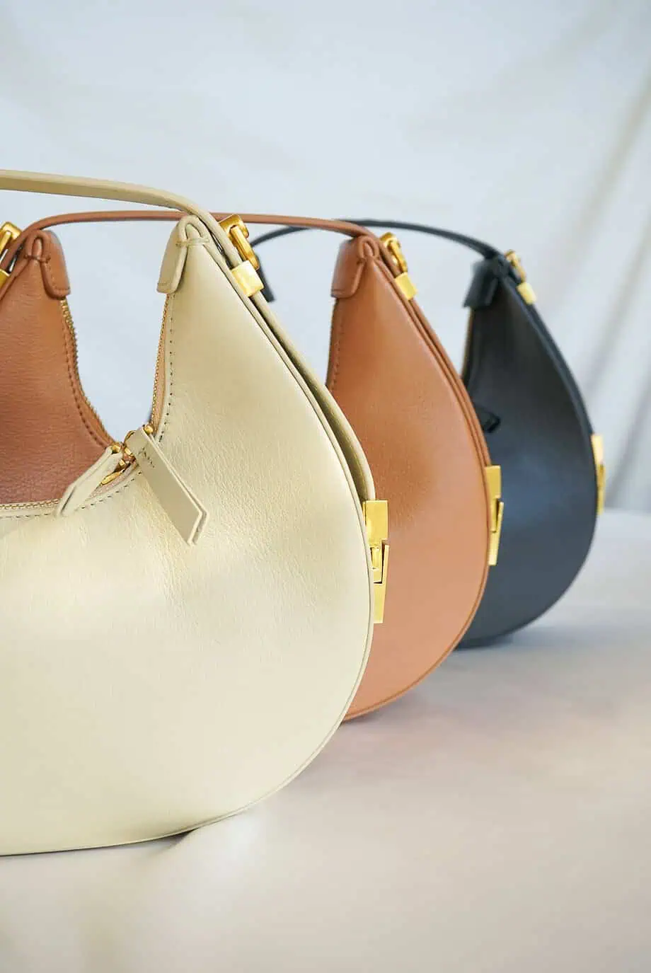 Leren schoudertas cognac bruine handtas coccinelle whisper look-alike designer dupe bag Osoi Toni tasje half moon halve maan tas beige zwart pistache