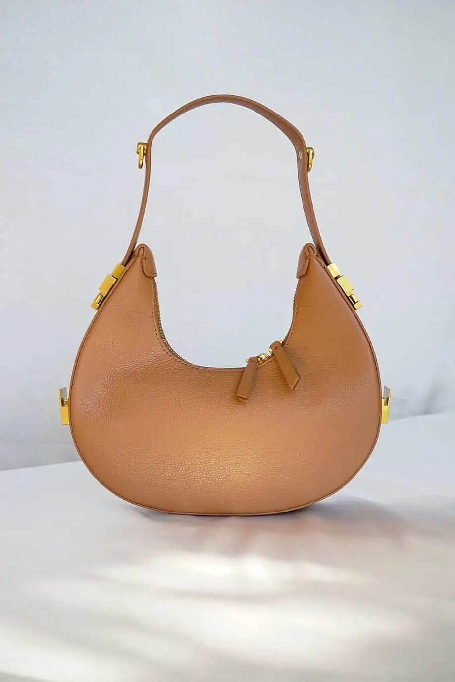 Leren schoudertas cognac bruine handtas coccinelle whisper look-alike designer dupe bag Osoi Toni tasje half moon halve maan tas uitschuifbaar hengsel