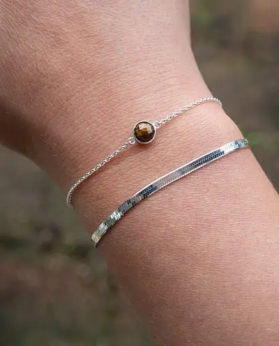 Deze stijlvolle zilveren armband is voorzien van een rond bruin edelsteentje van Tijgeroog, vervaardigd uit hoogwaardig Sterling Zilver