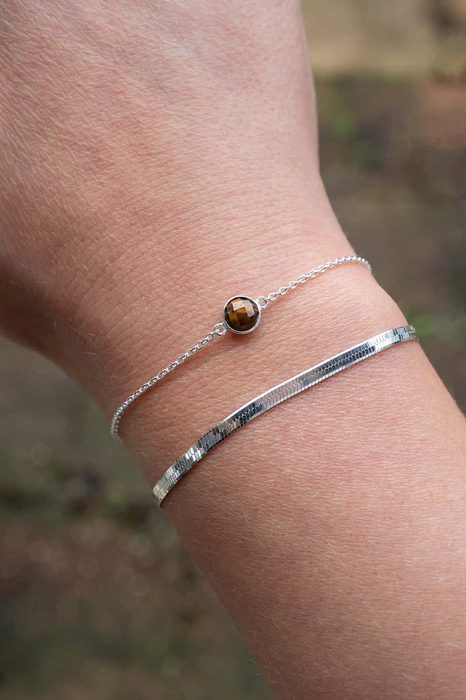 Deze stijlvolle zilveren armband is voorzien van een rond bruin edelsteentje van Tijgeroog, vervaardigd uit hoogwaardig Sterling Zilver