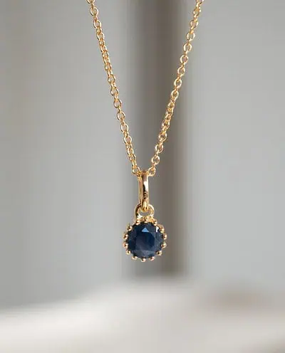 Gouden ketting met blauwe saffier edelsteentje geboortesteen van september sapphire donkerblauw van goud op zilver