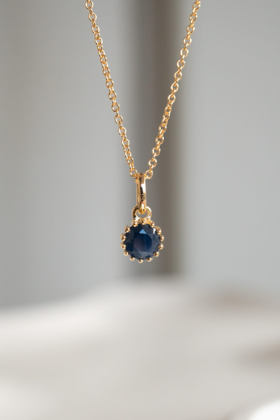 Gouden ketting met blauwe saffier edelsteentje geboortesteen van september sapphire donkerblauw van goud op zilver